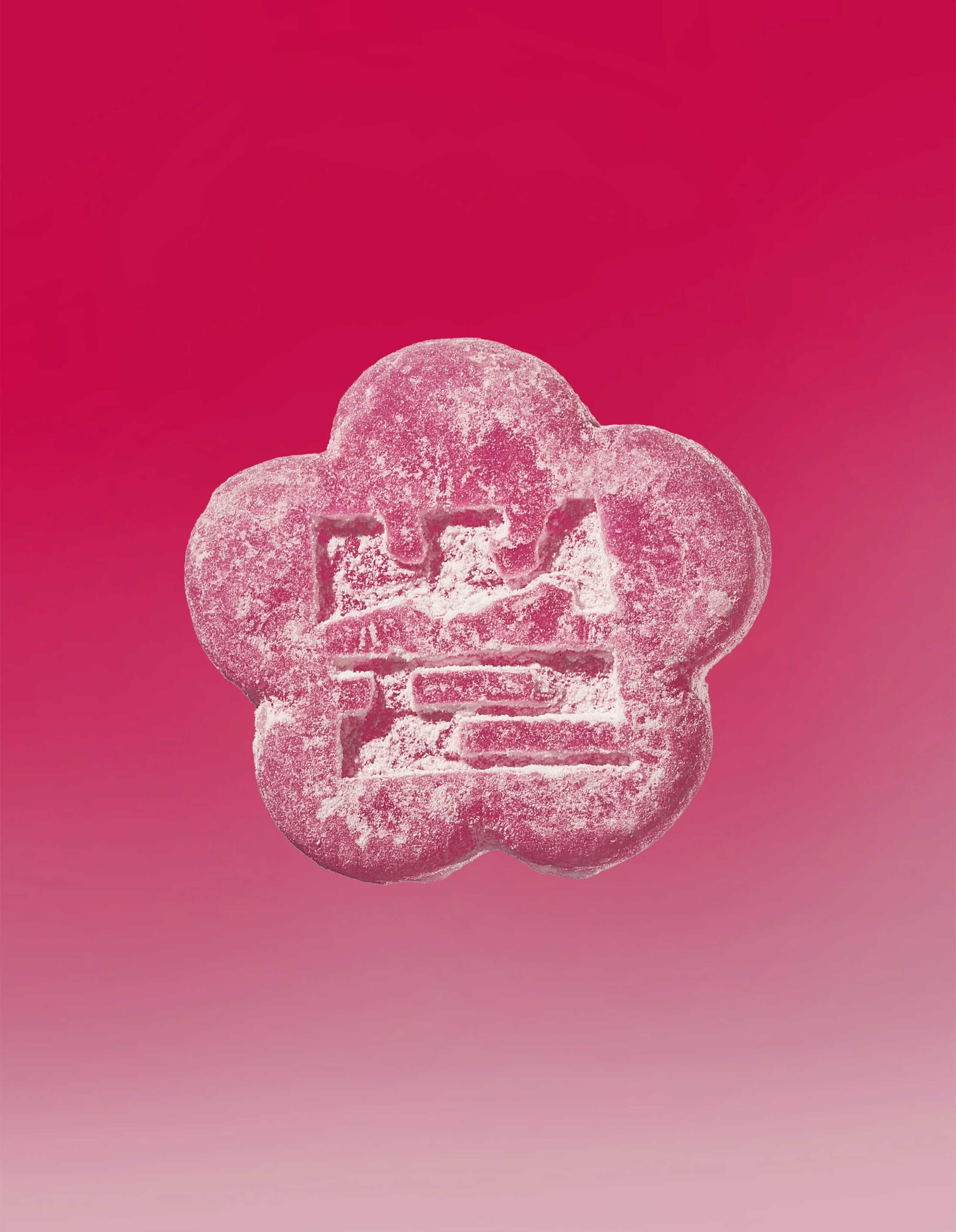 Image of a lychee dragon gummy on a gradient background going pink to light pink.