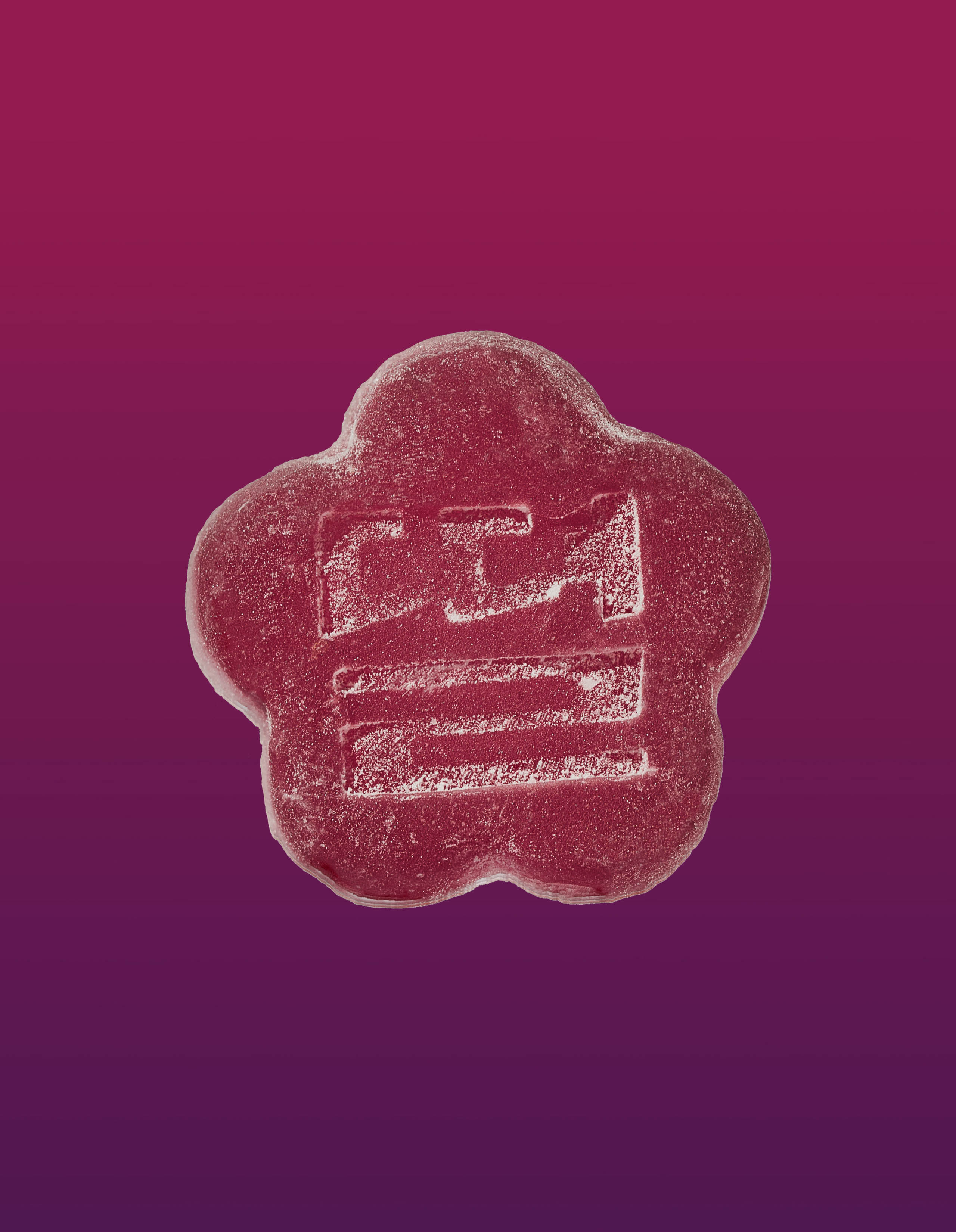 An image of a slumber berry gummy on a gradient background going pink to purple.