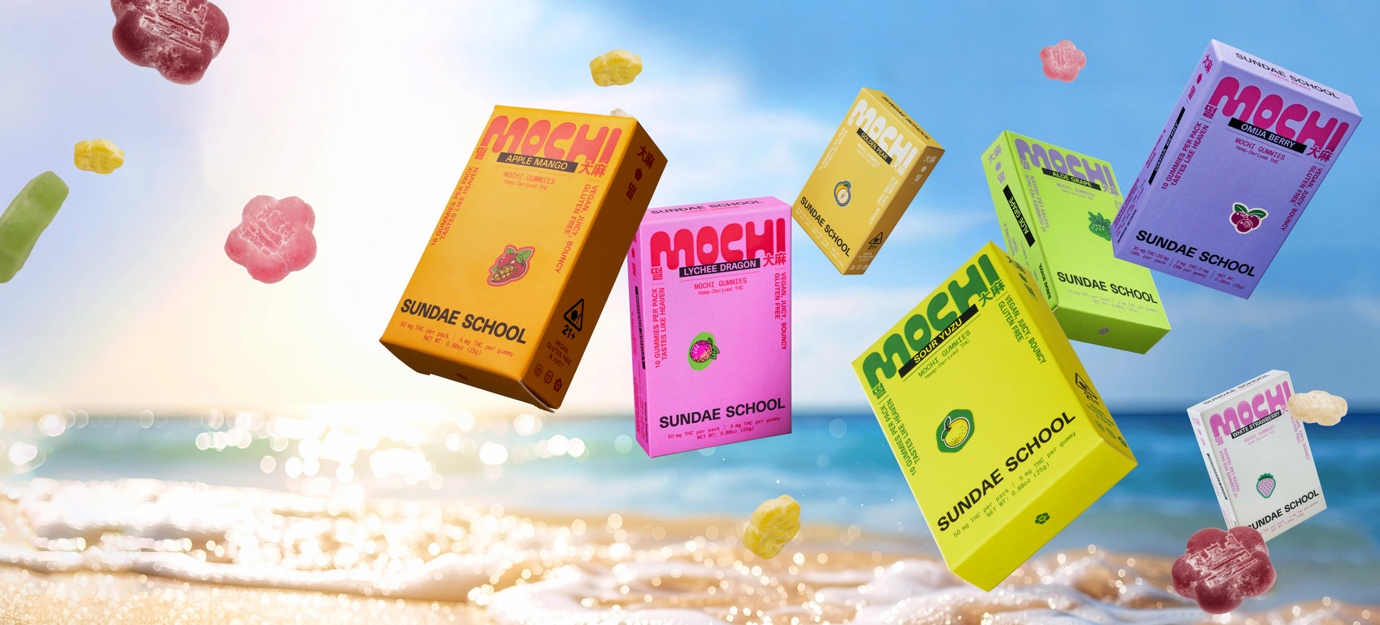 Seven colorful Sundae Flower mochi boxes -- Apple Mango Lychee Dragon, Sour Yuzu, Golden Pear, Aloe grape, Omija berry, White Strawberry --  in various flavors float above a sunny beach shoreline, with waves crashing and the ocean in the background. 