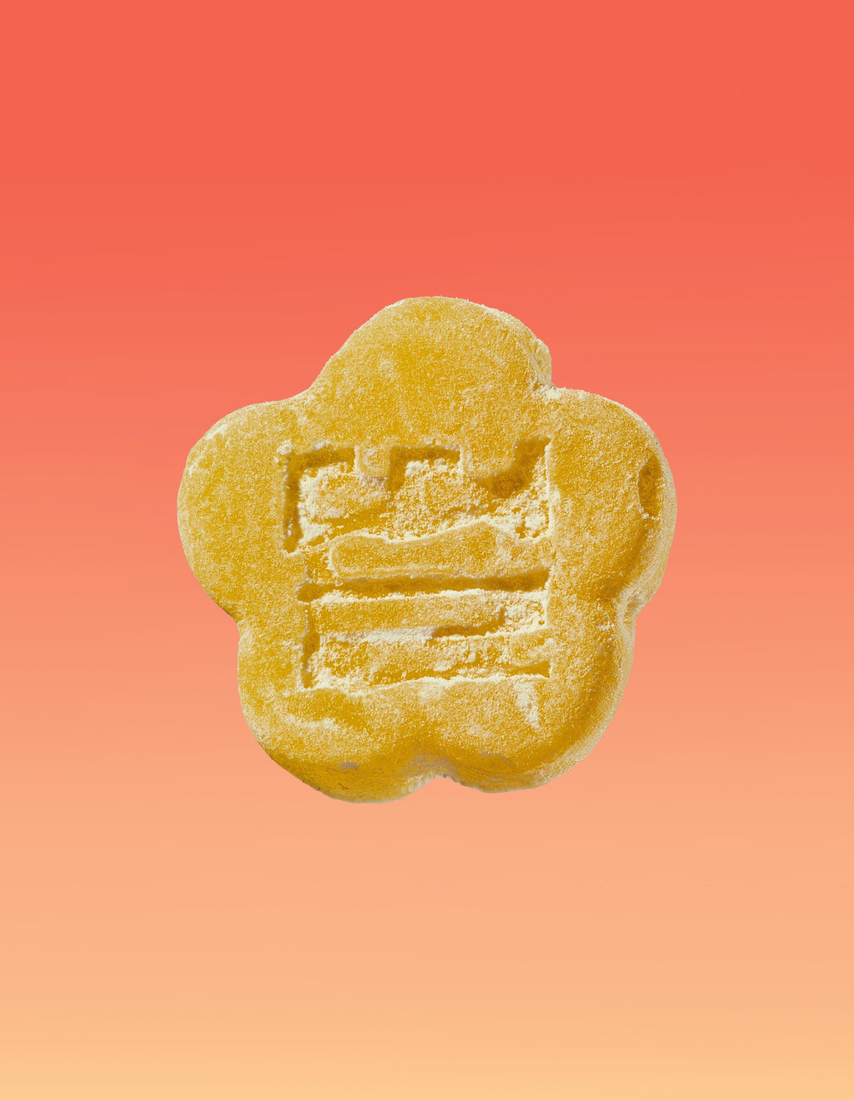 An image of a Kimchee Yuzu gummy on a gradient background going pink to yellow. 