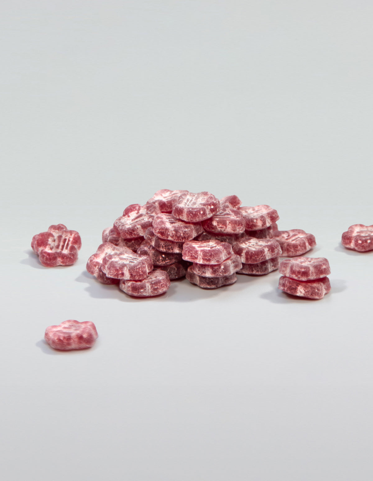 An image of a pile of Slumber Berry gummies stacked and scattered on a white surface.