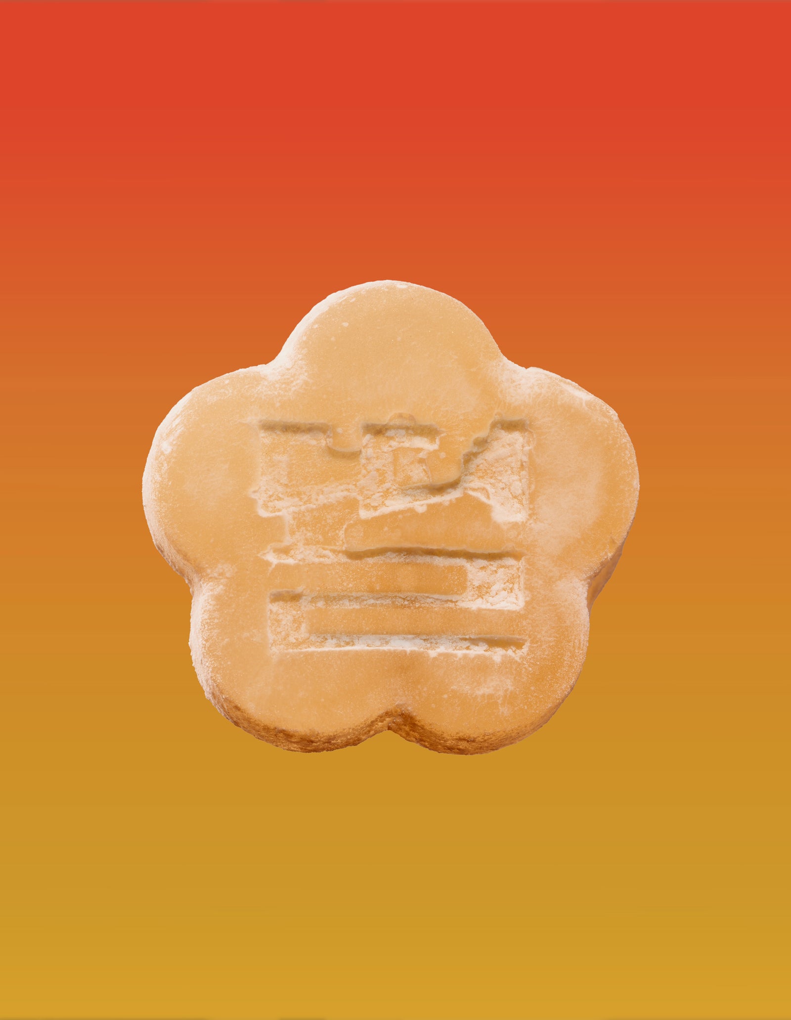 An image of an apple mango gummy on a gradient background going orange to yellow.