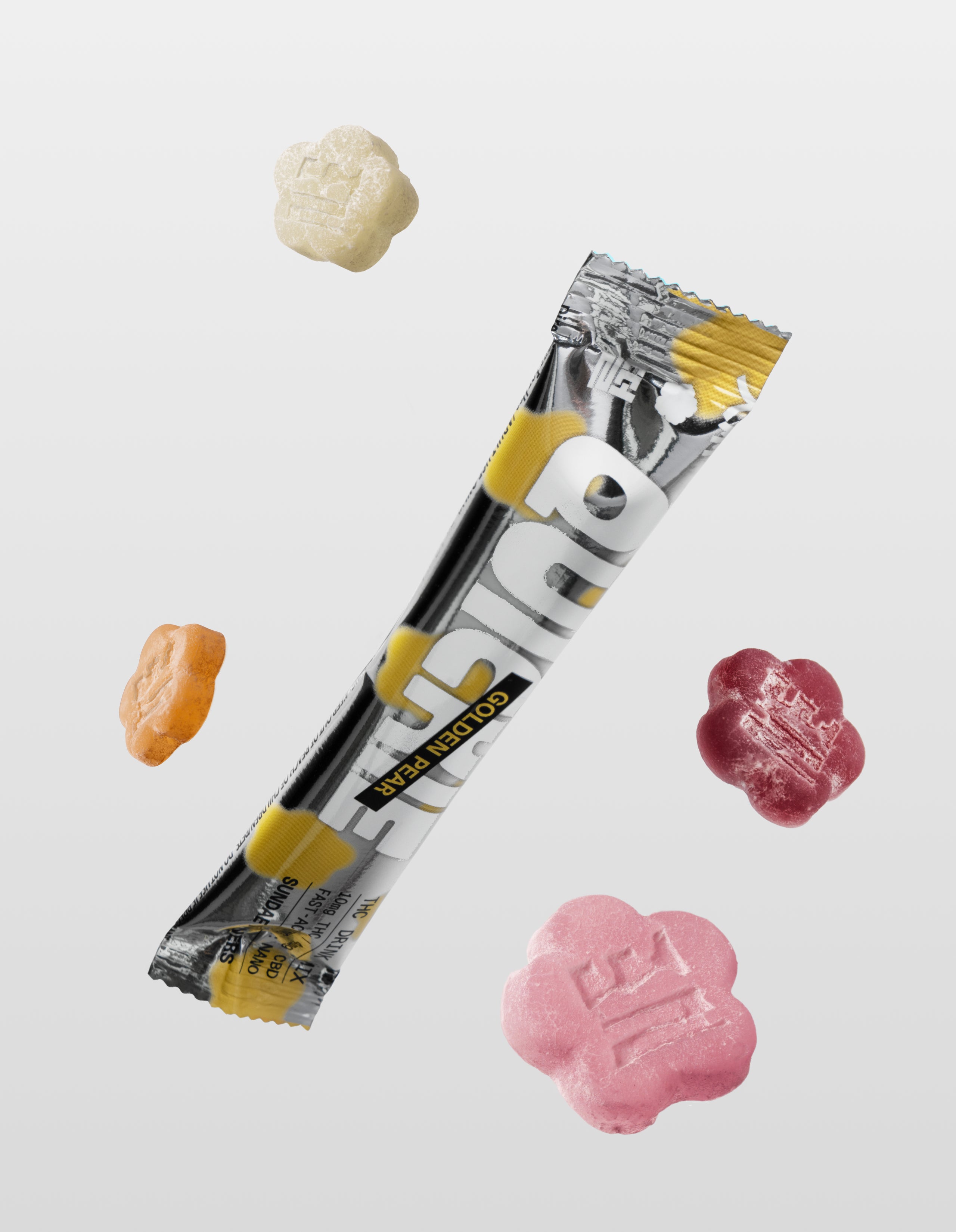 A Golden Pear Quickie drink mix packet floating diagonally, surrounded by four flower-shaped mochi gummies in various colors—cream, amber, dark purple, and pink—against a minimalist gray background.
