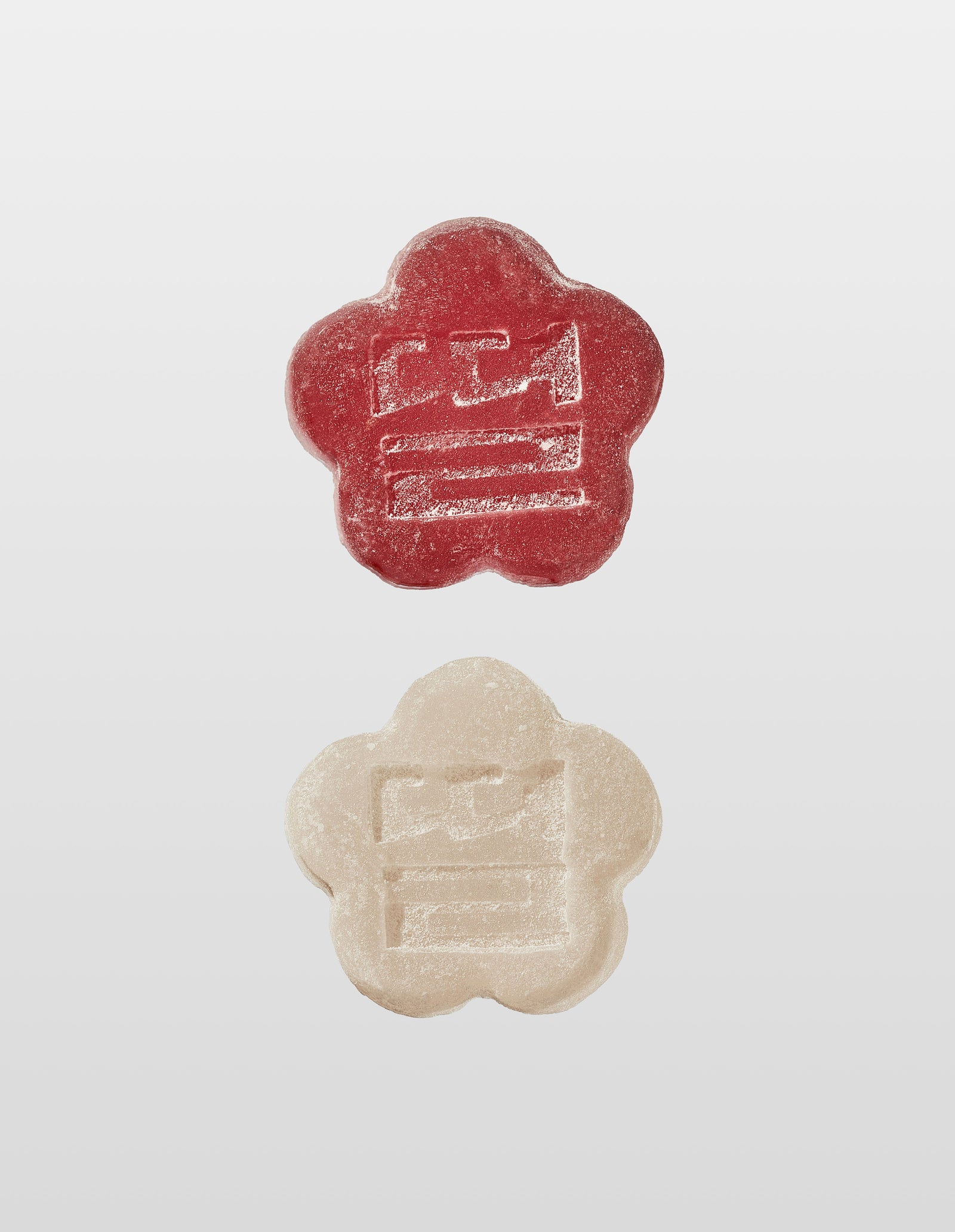 Two Mochi gummies are shown vertically against a white background. The top gummy is Slumber Berry and the bottom is White Strawberry, both with an embossed design of the companies logo 'Ddul' spelt out in Korean. 