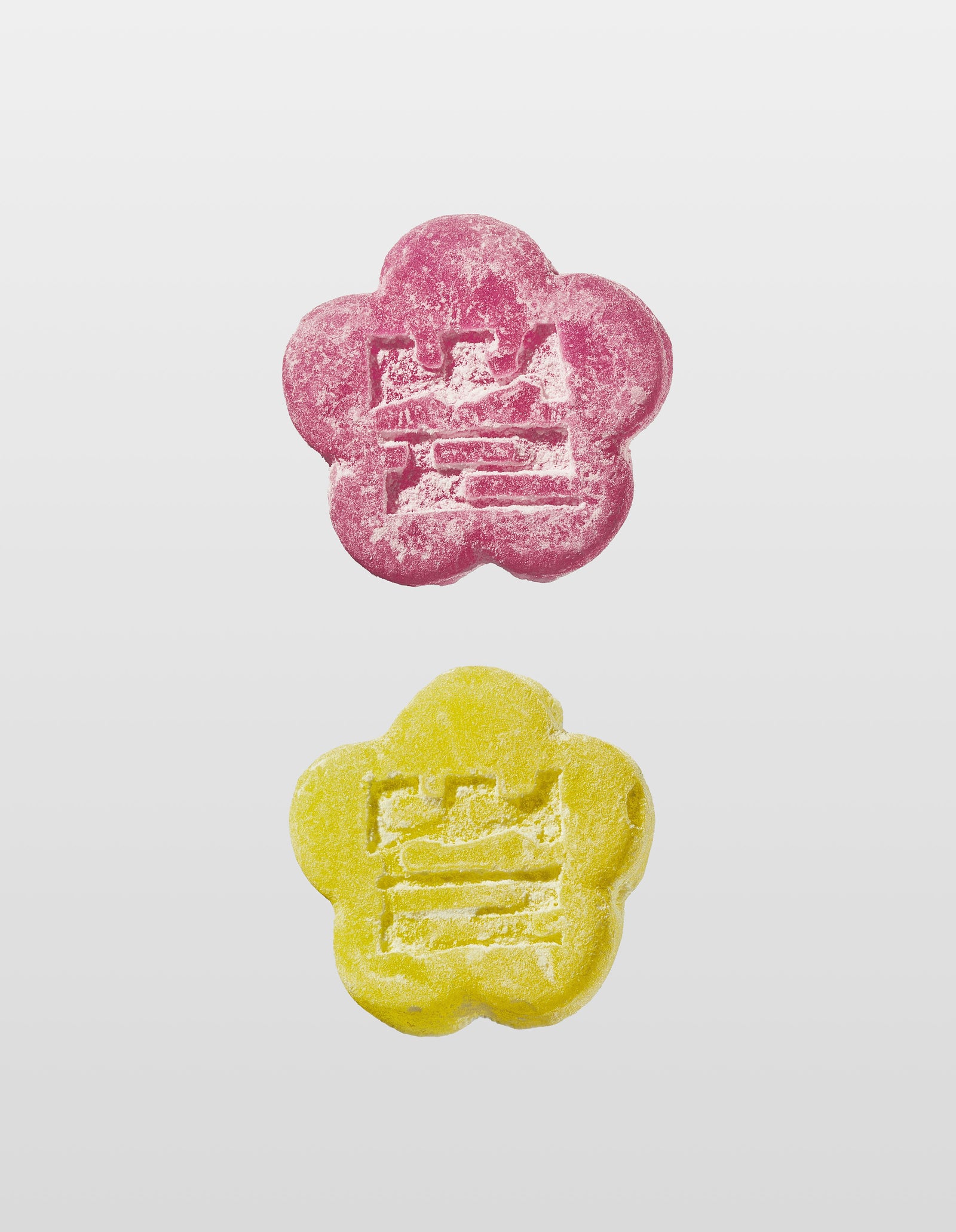 Two Mochi gummies are shown vertically against a white background. The top gummy is Lychee Dragon and the bottom is Sour Yuzu, both with an embossed design of the companies logo 'Ddul' spelt out in Korean. 
