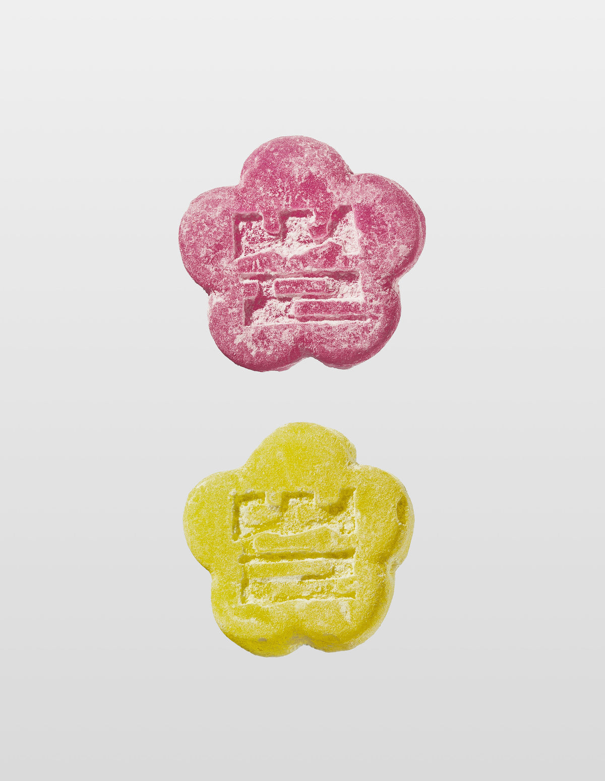 Two Mochi gummies are shown vertically against a white background. The top gummy is Lychee Dragon and the bottom is Sour Yuzu, both with an embossed design of the companies logo 'Ddul' spelt out in Korean. 