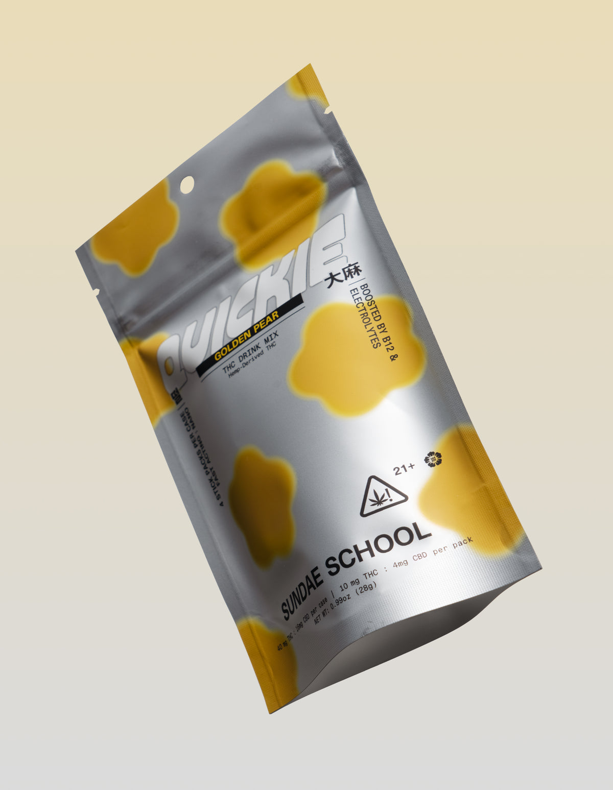 A silver metallic resealable pouch of Sundae School "Quickie" Golden Pear flavored THC drink mix, floating at an angle against a soft beige gradient background. The package is decorated with amorphous, bright yellow blob shapes and features bold white branding alongside cannabis warning icons and product dosage info.